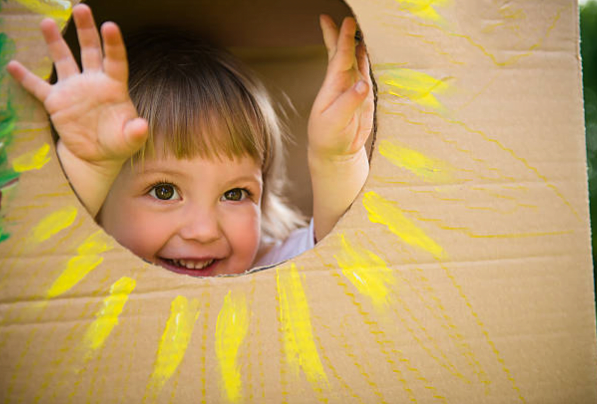 Baby girl in homemade craft toy house