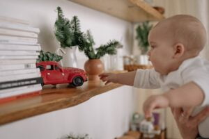 Baby reaching with nanny to get a toy car