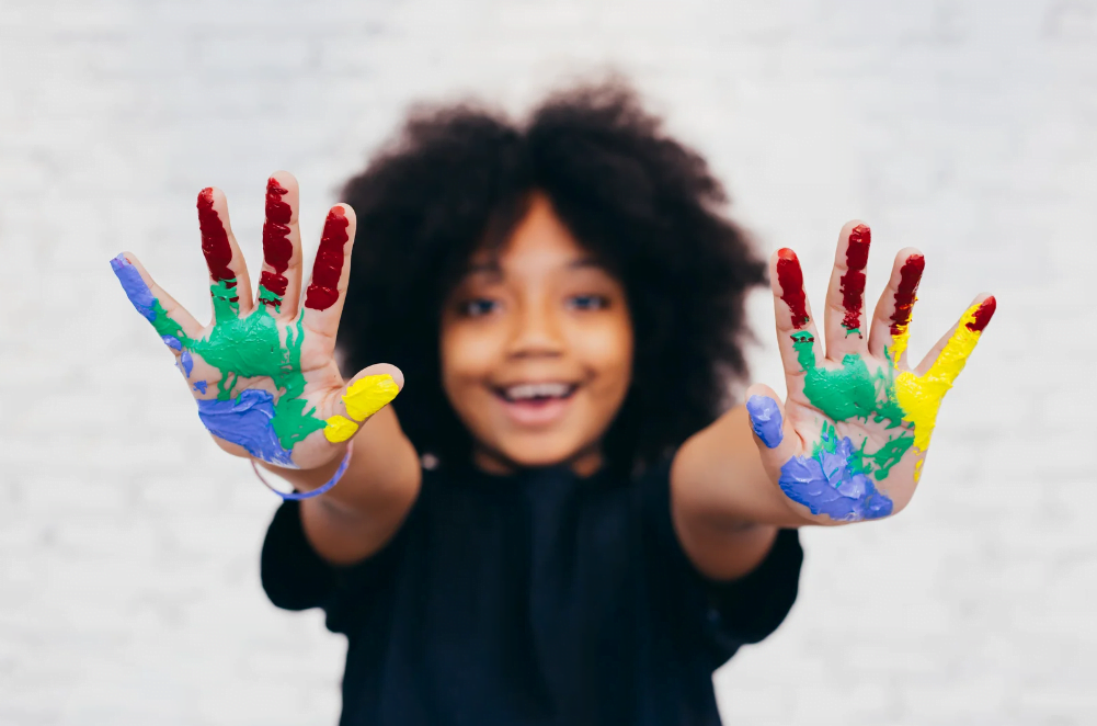 Young girl learning through play in childcare painting