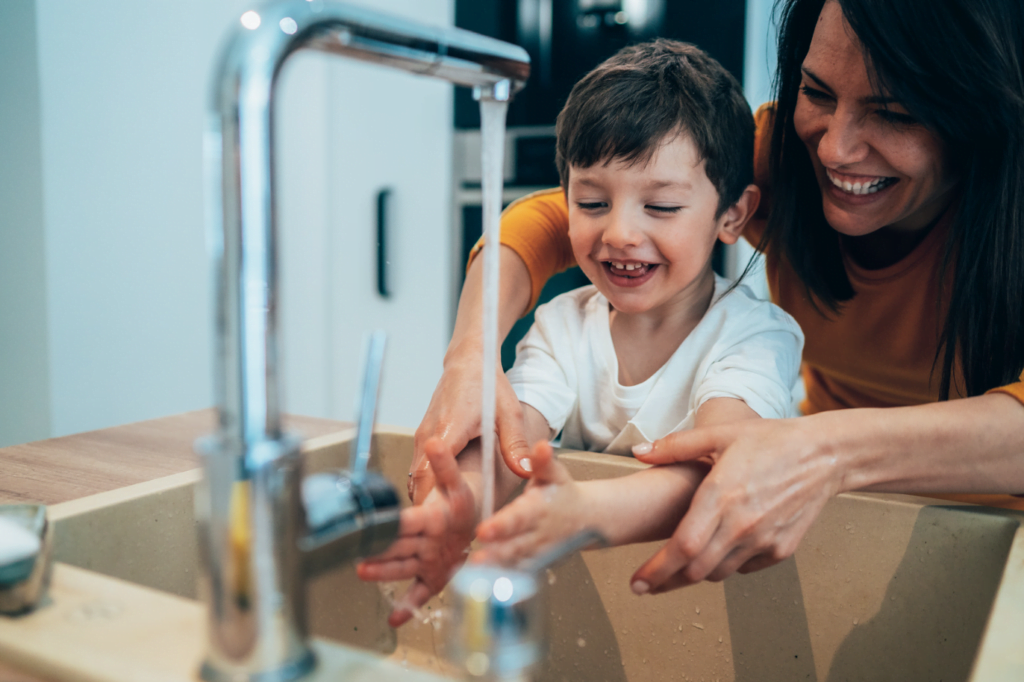 Childminder washing boys hands prevent bacterial meningitis