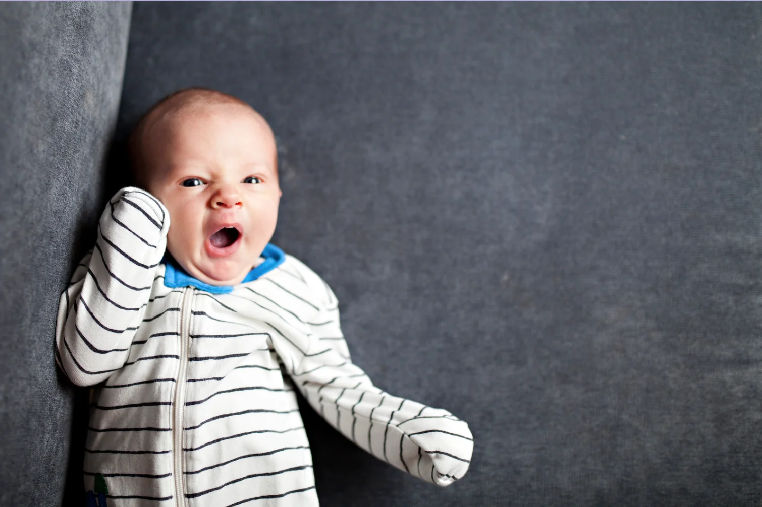 Newborn baby grunting, squirming and yawning during sleep