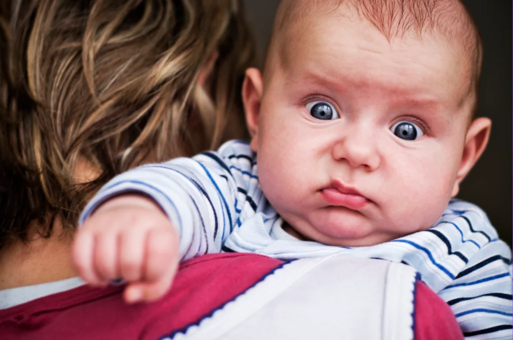 Baby discomfort passing stool during night with parent.