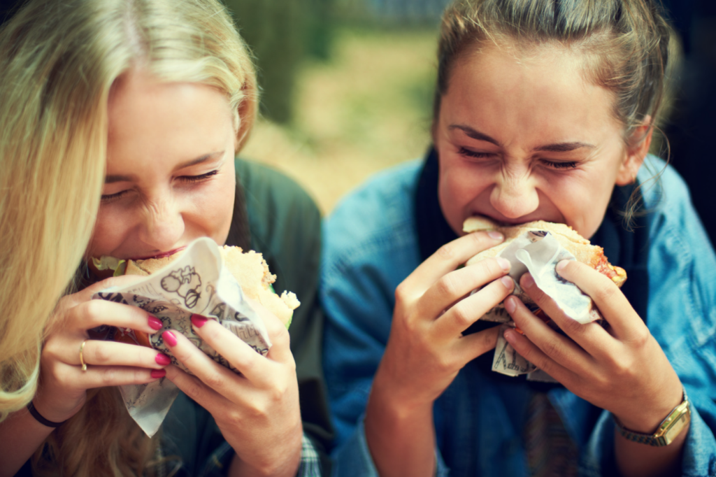 13 year old girls eating food and laughing at jokes