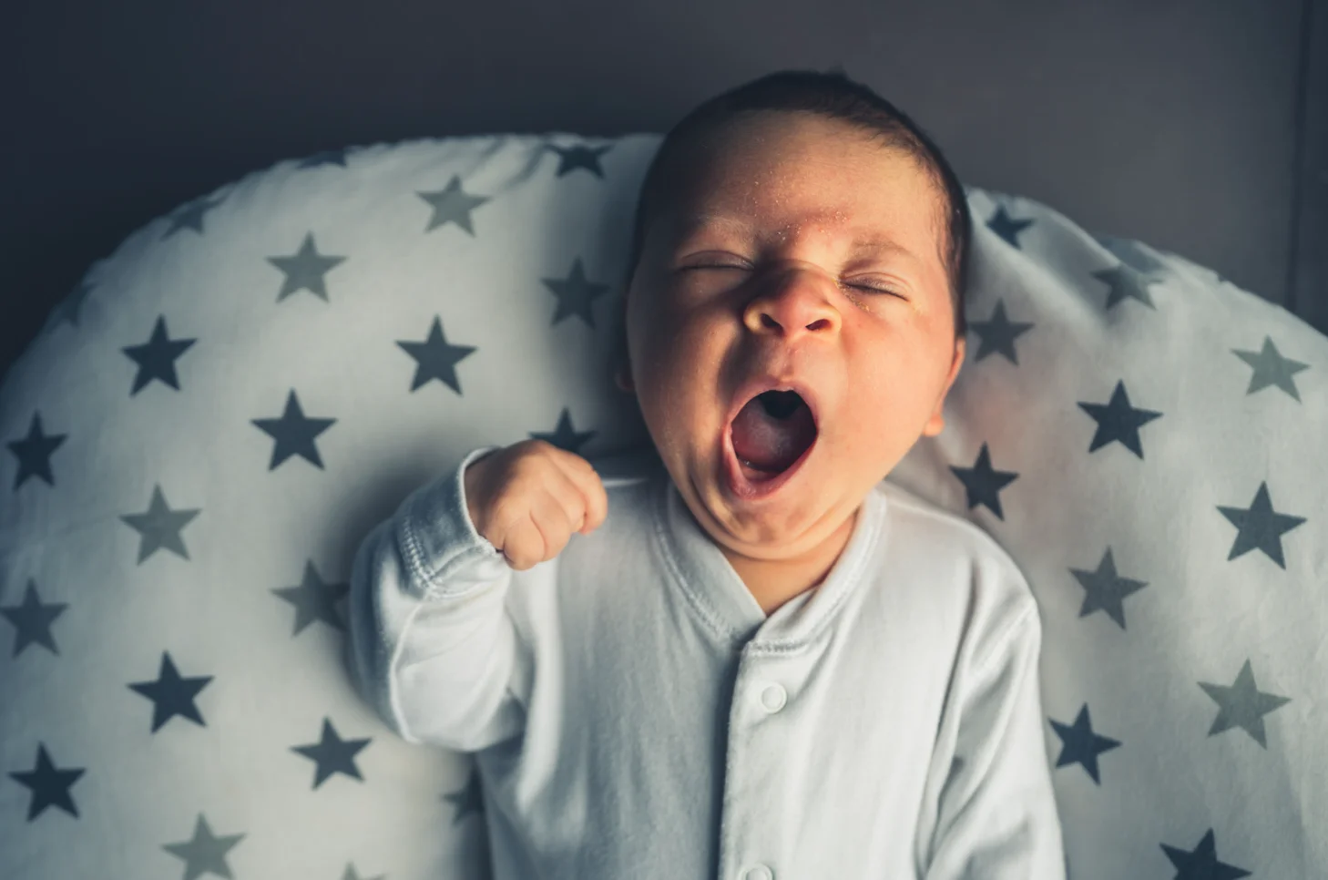 Baby with grunting baby syndrome taking big yawn