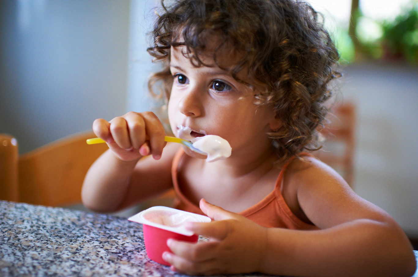 Child eating yoghurt is good for their digestive systems