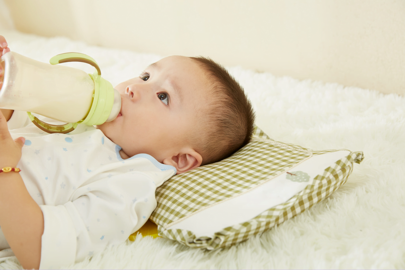 A child having bottle of milk until they are able to have solid food