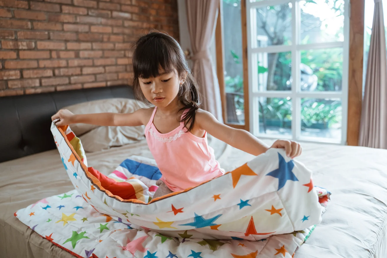 child building self esteem and shown good example making bed
