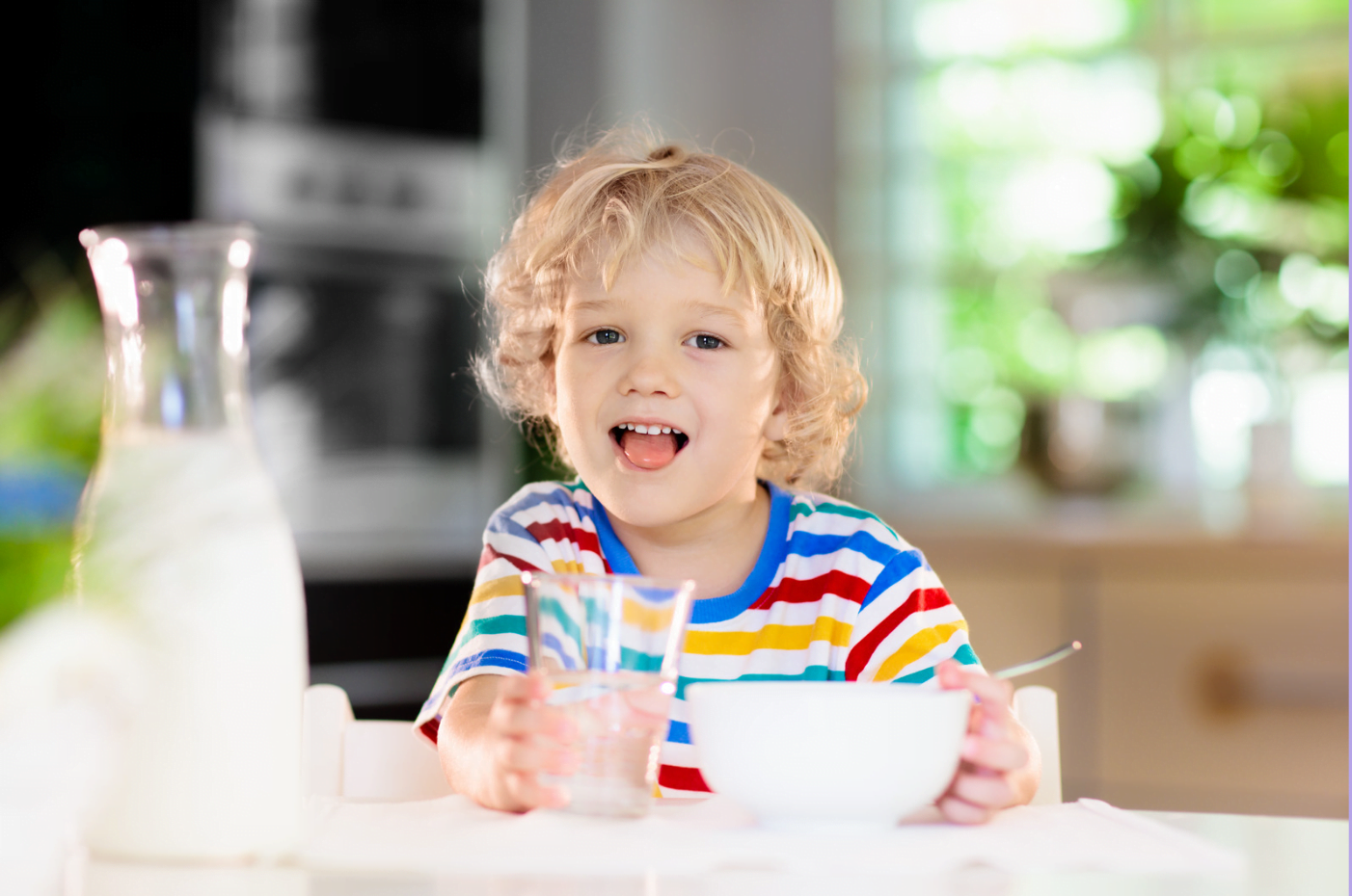 A young child drinking a glass of milk as main drink