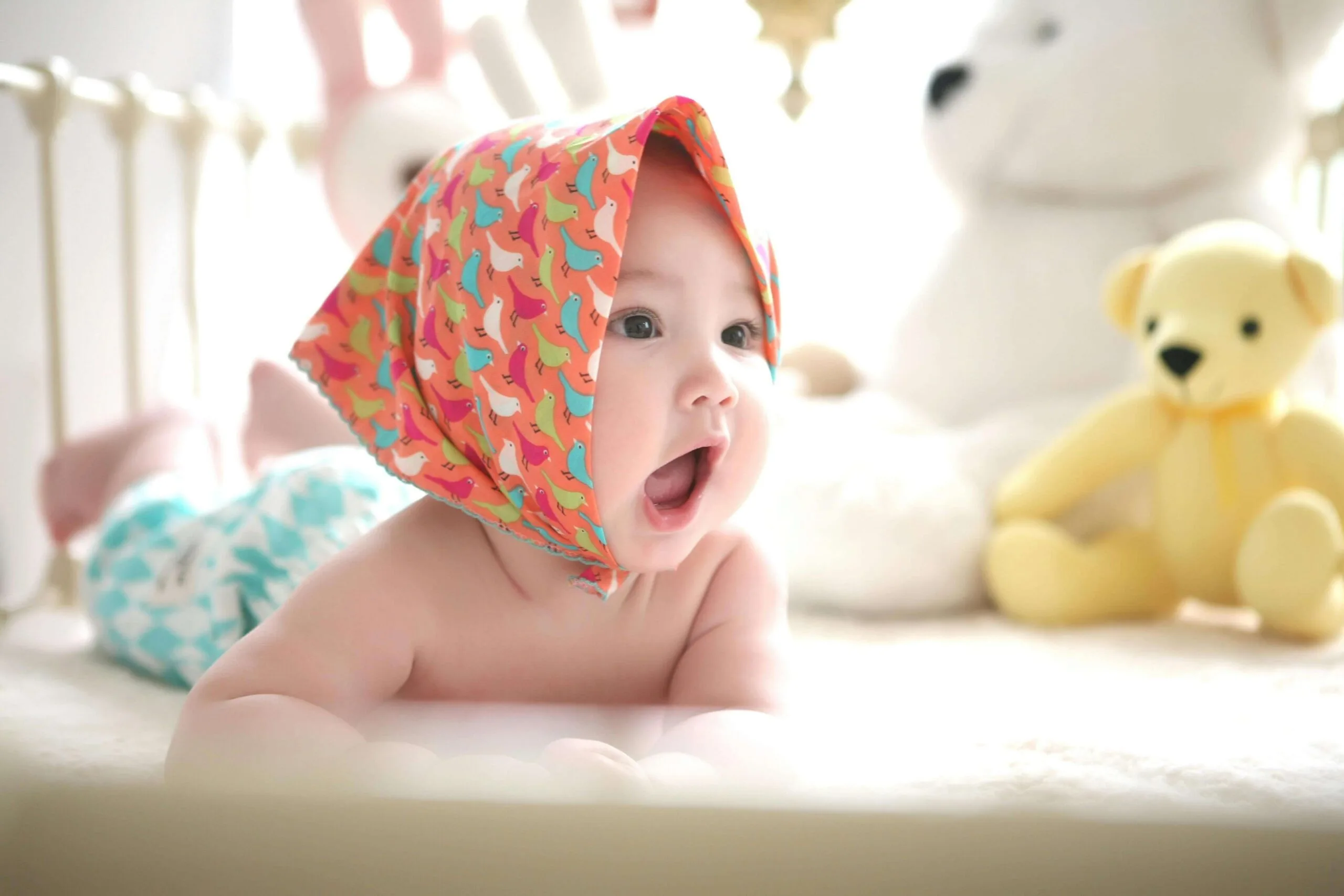 baby with mouth open about to coo or squeals instead of babbling