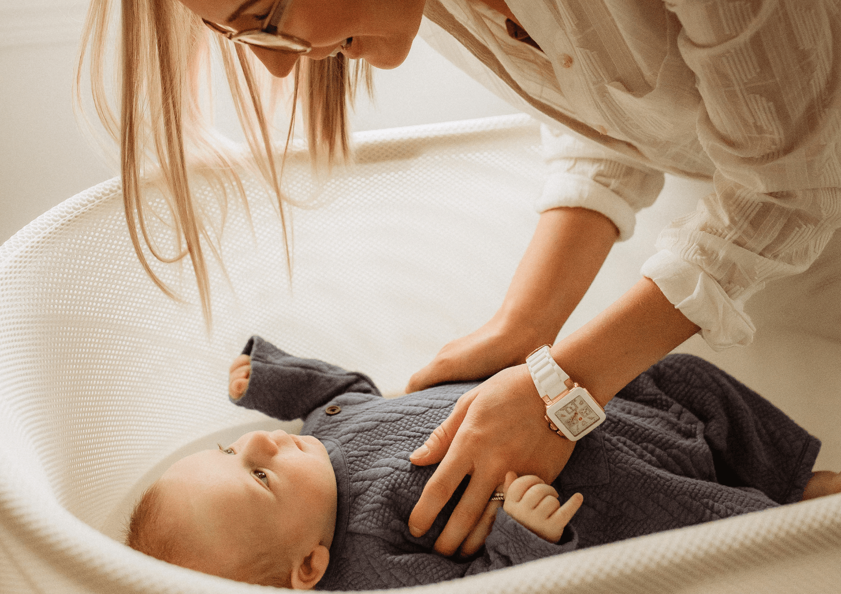 Mother with baby in crib on maternity allowance 